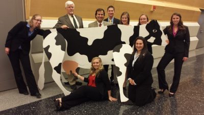 2014 Virginia Tech Dairy Challenge delegation posing with a faux Holstein.