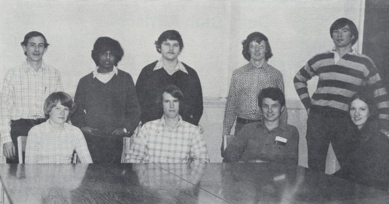 From the 1976 Milky Way.  Graduate Students. "They keep the research going!" (L to R) Seated: Margaret Jamison, John Clay, Ted Friend, Mary Sowerby. Standing: John Chandler, Mahendra DeSilva, Mike Akers, Mike O'Conner, Chuck Sera.